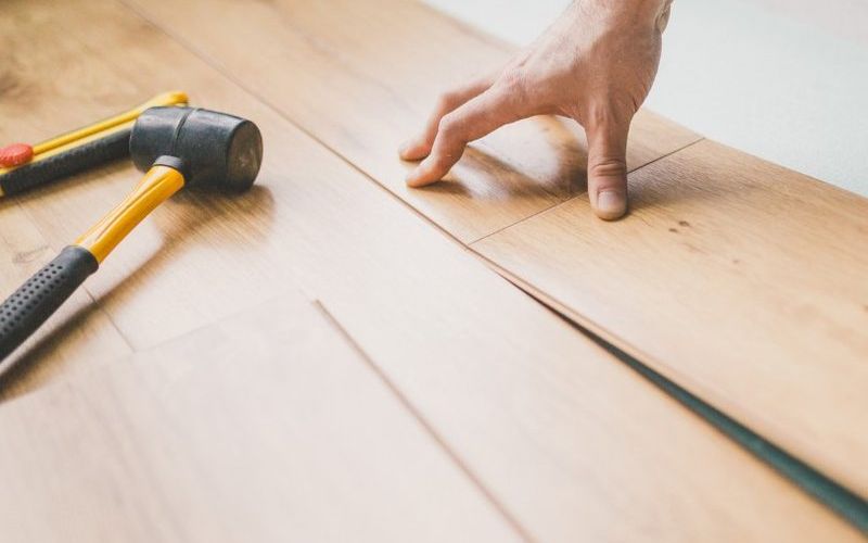 Montaje de lamas de suelo con acabado madera en una vivienda