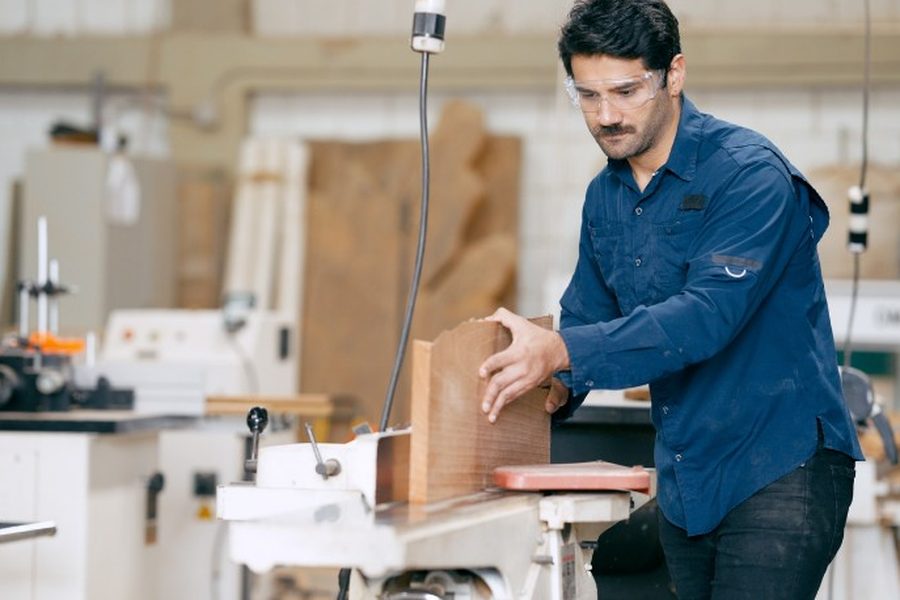 Carpintero mecanizando una pieza del interior de un armario empotrado en el taller de Soria