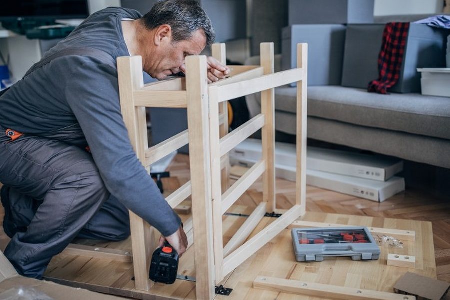 Carpintero montando en vivienda un mueble de madera fabricado a medida en Soria