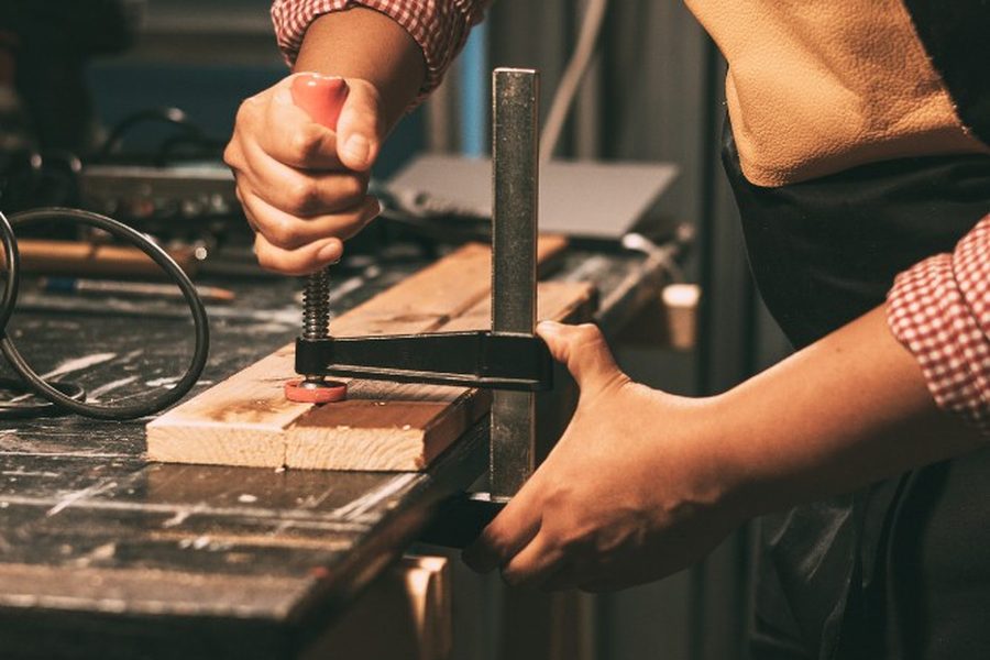 Reencolado y prensado con sargento de una pieza de madera en el taller de Soria